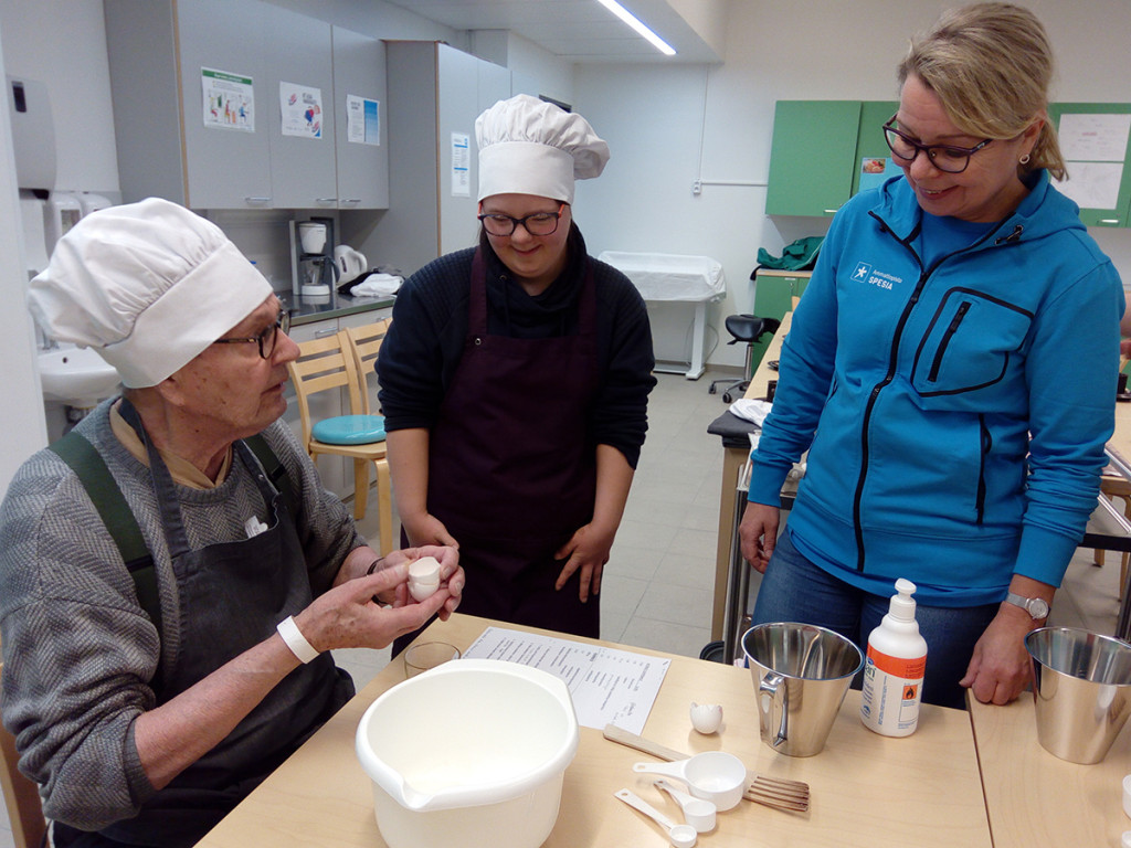 Kuntoutuja leipoo, opiskelija ja opettaja kannustavat