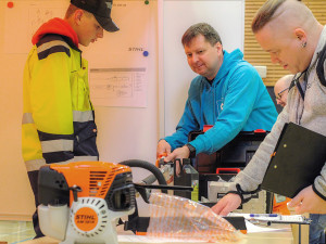 TaitajaPLUS 2019 kiinteistönhoidon semifinaali, kilpailija ja kaksi tuomaria tarkistavat koottua kombi-konetta