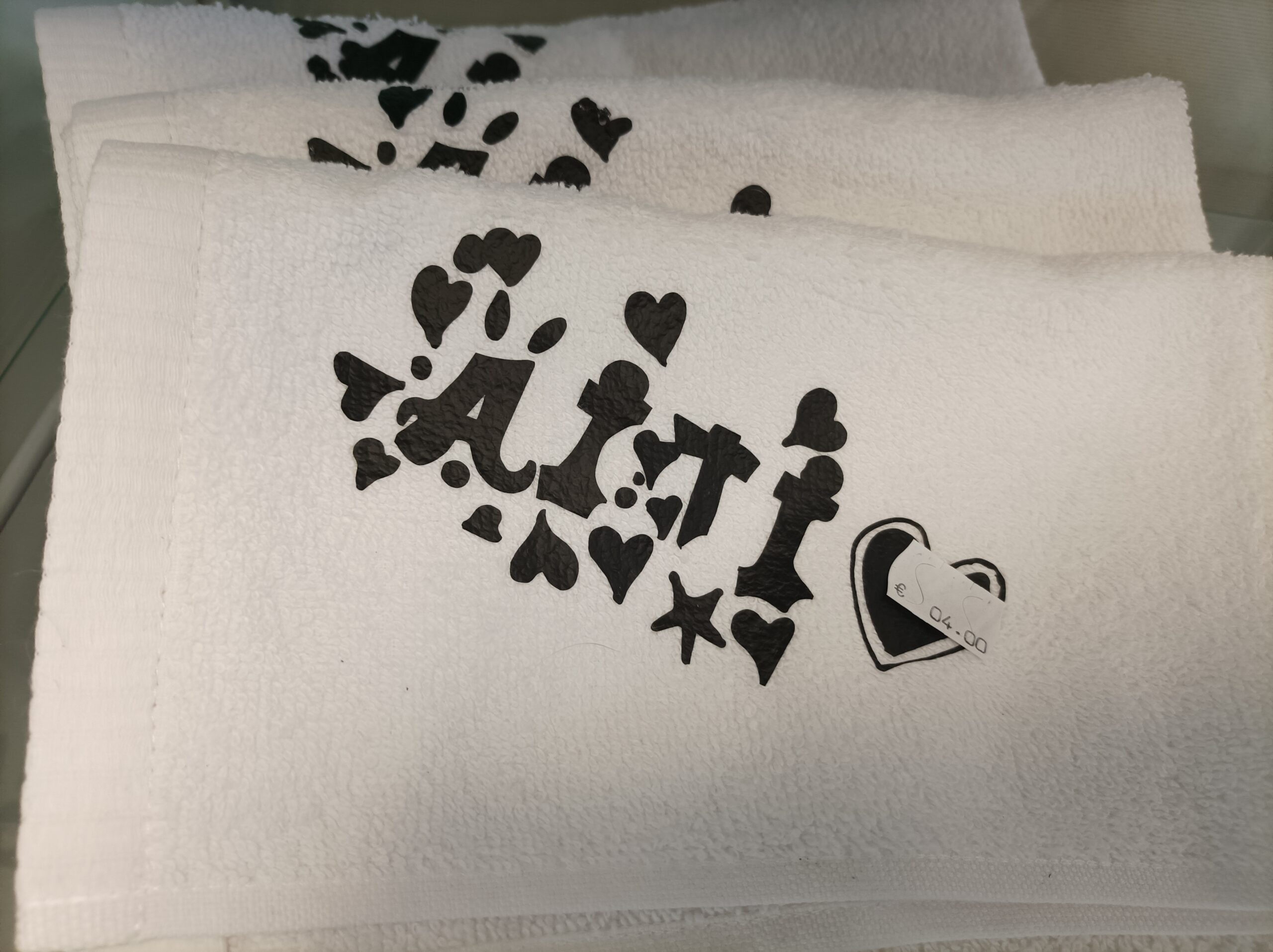 Valkoisia pyyhkeitä, joissa musta "äiti" painatus.