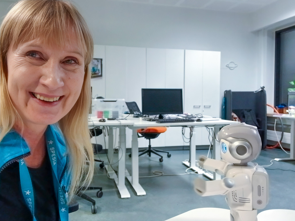 Spesian opo ja pieni valkoinen robotti luokkahuoneessa.