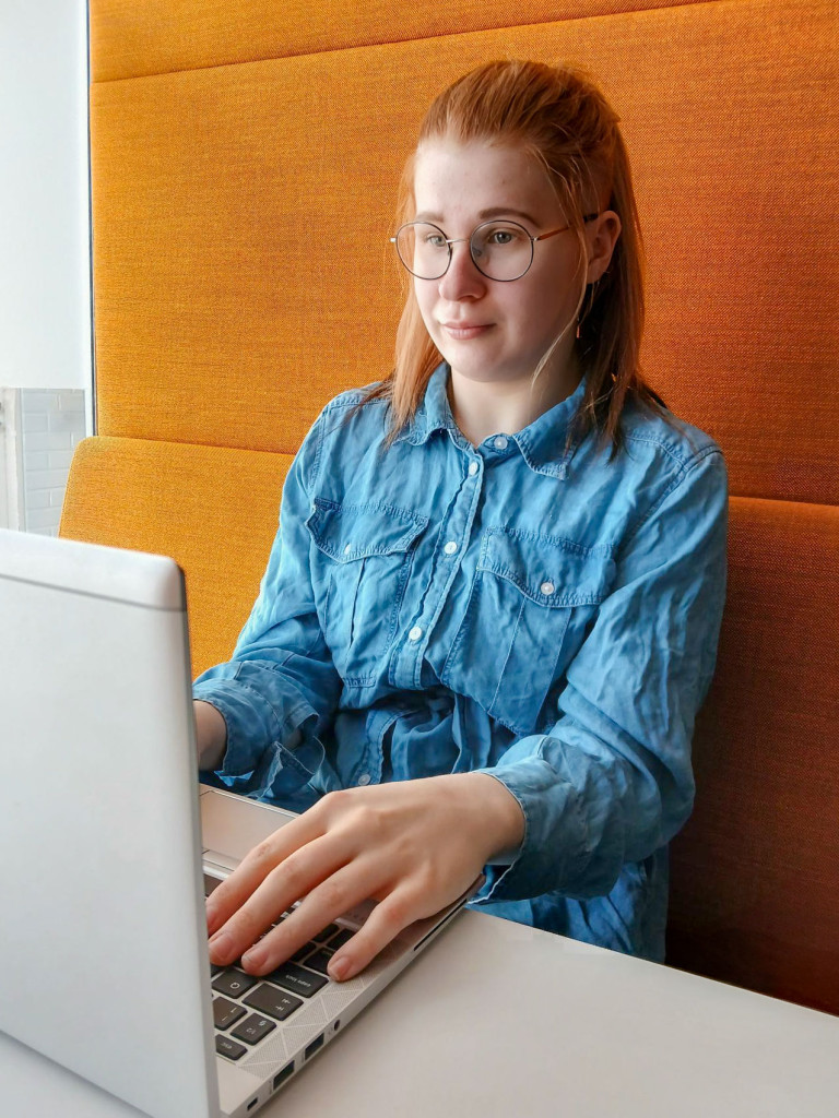 Nainen istuu tietokoneella.