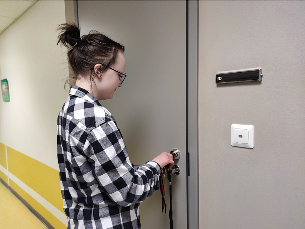 Opiskelija avaa oman asuntonsa ovea asuntolassa.