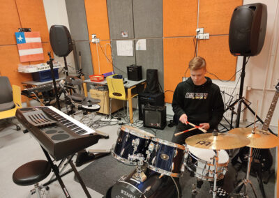 Nuori mies soittaa rumpuja Jyväskylän asuntolan bändihuoneessa.