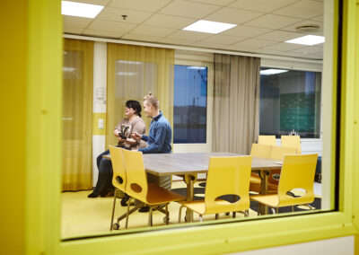 Kaksi nuorta pelaa kerhotilassa pleikkaria.