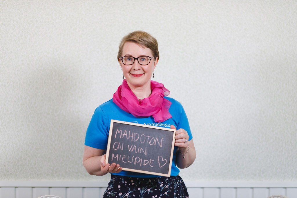 Maria Ojala-Vesteri pitelee edessään liitutaulua, jossa lukee Mahdoton on vain mielipide.