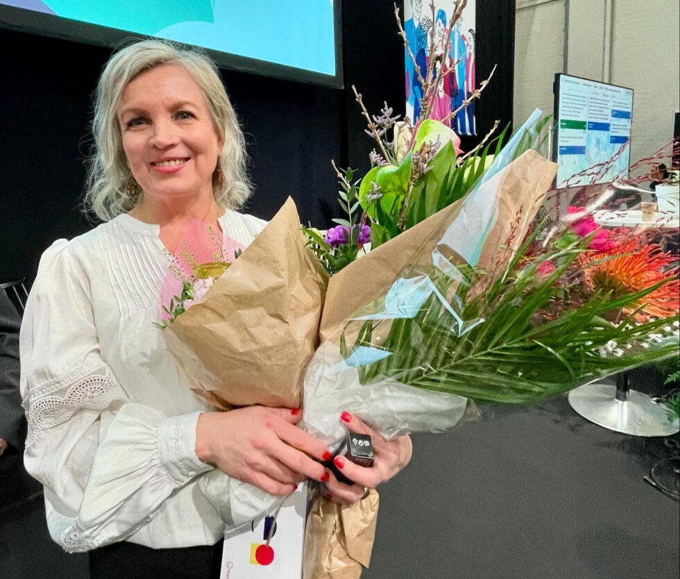 Tuula Niskanen kukkapuskia sylissään.