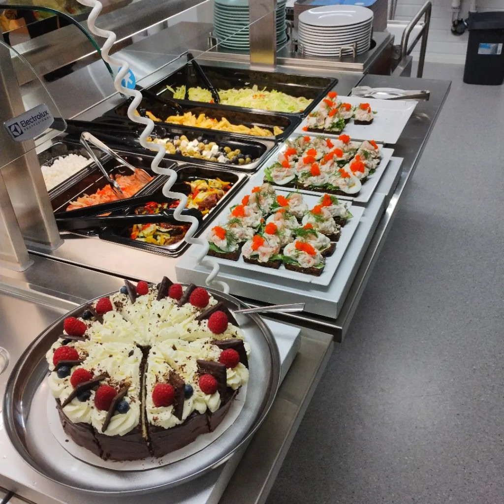 Lounaslinjastolla salaattivalokoima, leipää ja herkullinen suklaakakku.