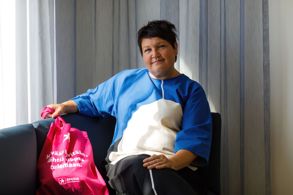 Marika Mäkinen istuu tuolissa pinkki kangaskassi vieressään.