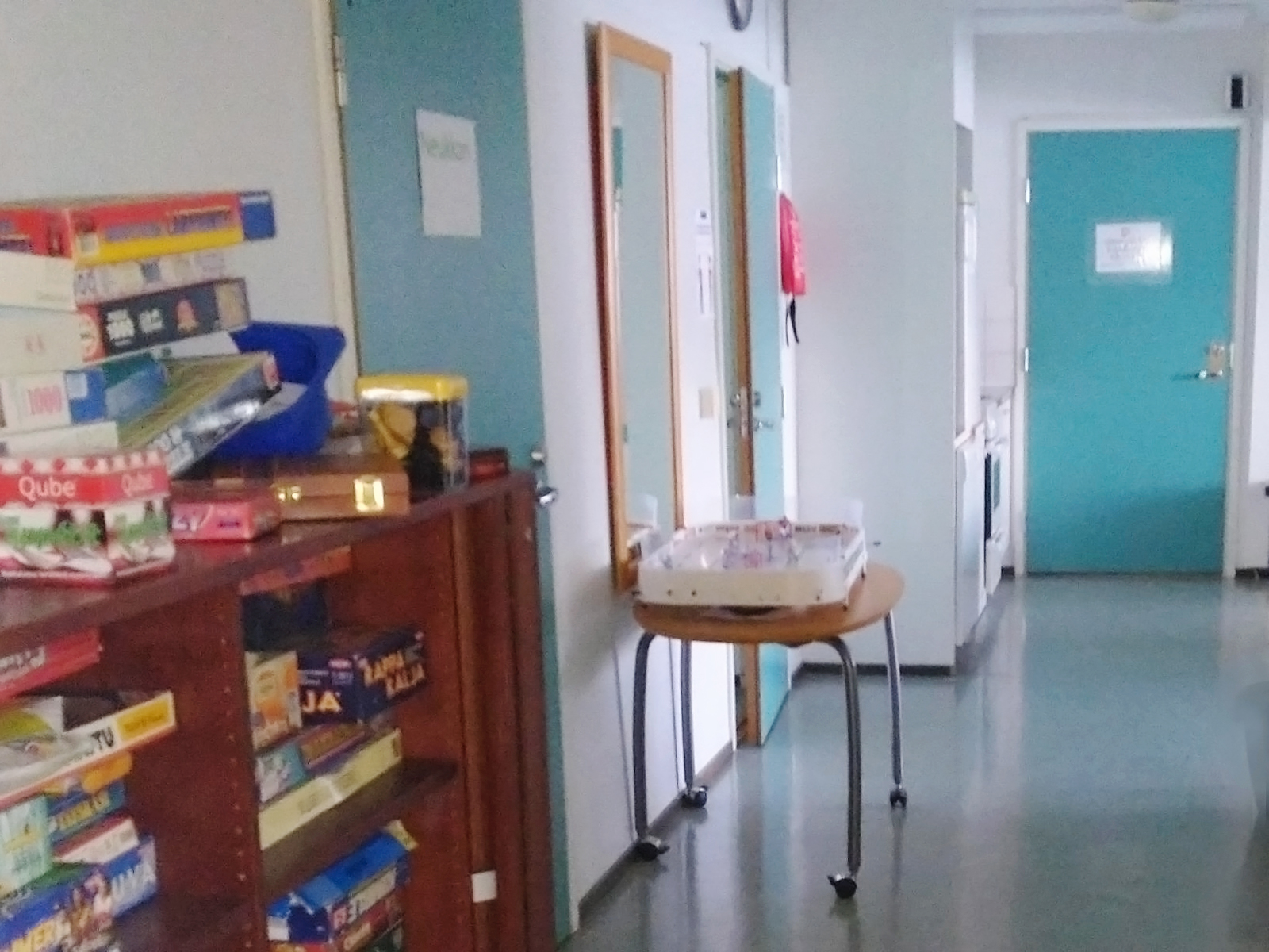 Käytävänäkymä, reunassa hylly, jossa lautapelejä.